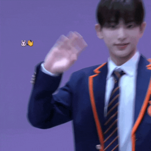 a man in a suit and tie is waving his hand in front of a purple background
