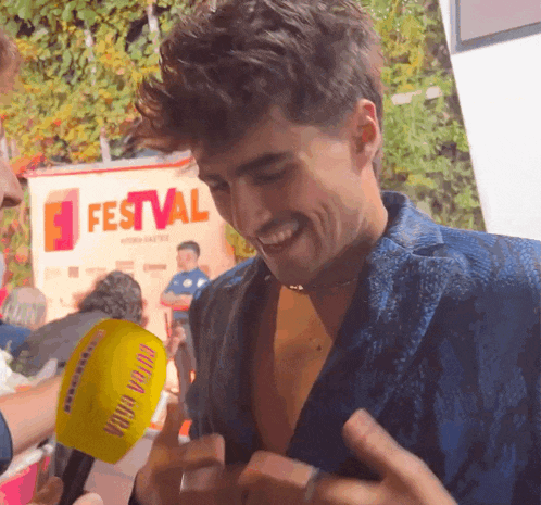 a man is being interviewed by a yellow microphone with the word festival on it