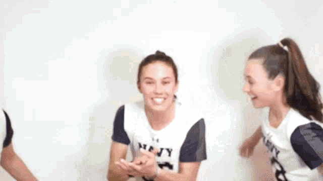three young women are standing next to each other and smiling .