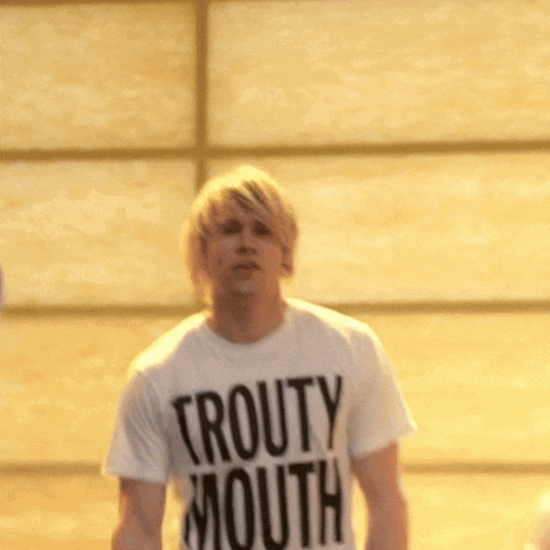 a man wearing a white shirt that says trout mouth