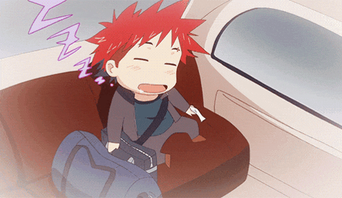 a boy with red hair is sleeping in the back seat of an airplane