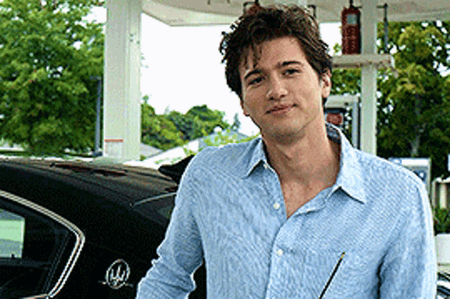 a man is standing in front of a buick car