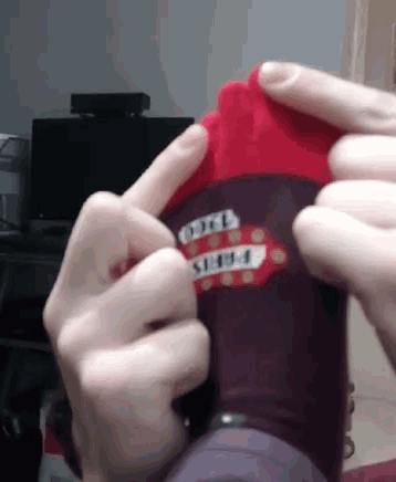 a person is putting on a pair of socks with a sticker on it that says ' pablo '