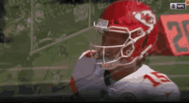 a football player wearing a red helmet and number 15 on his jersey .