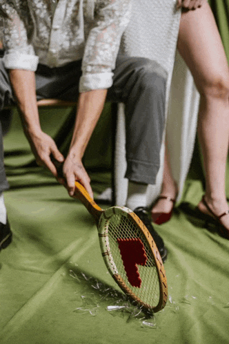 a man is holding a tennis racquet with a heart on the net