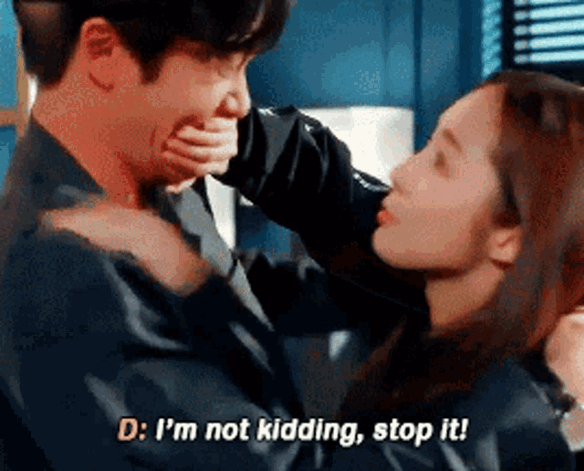 a woman is covering a man 's mouth with her hand and says " d : i 'm not kidding stop it "