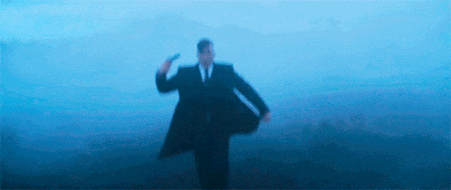 a blurry picture of a man in a suit and tie holding a gun