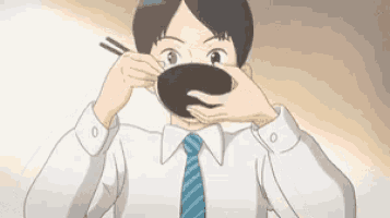 a man in a tie is holding a bowl in front of his mouth .