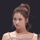 a close up of a woman 's face with a ponytail and a bra .