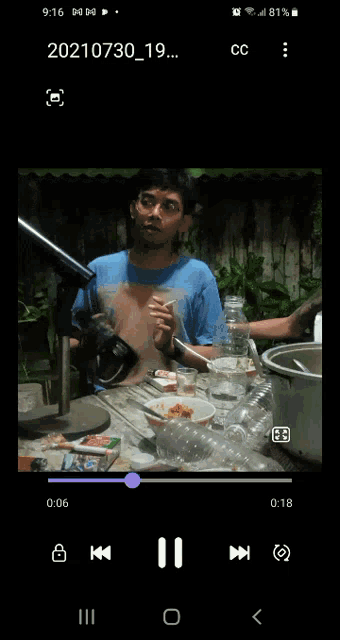 a video of a man sitting at a table is being played on a cell phone