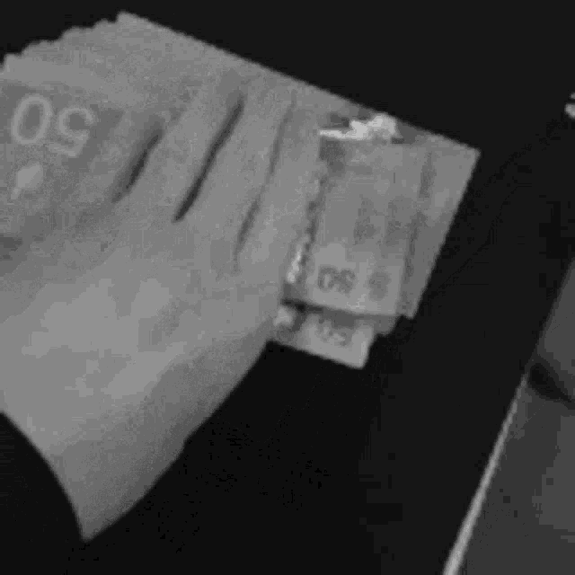 a black and white photo of a person holding a bunch of money .
