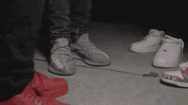 a person wearing a pair of white sneakers stands next to another person wearing a pair of red shoes