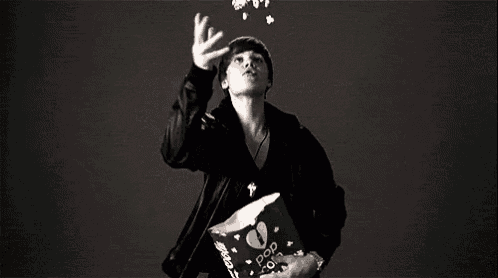 a man is holding a bag of pop corn in his hand .