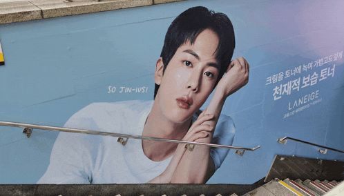 a billboard of a young man with the name jin-iusi on it