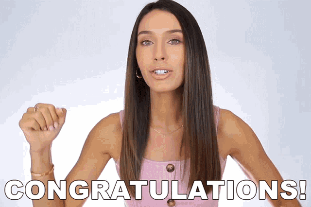 a woman in a pink tank top says congratulations with her fist in the air