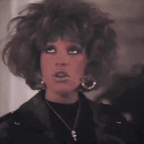 a close up of a woman 's face wearing a leather jacket and hoop earrings