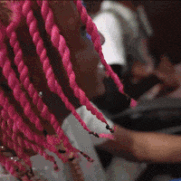 a close up of a person 's pink braids