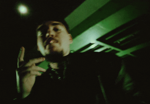 a blurry picture of a man smoking a cigarette in a dark room