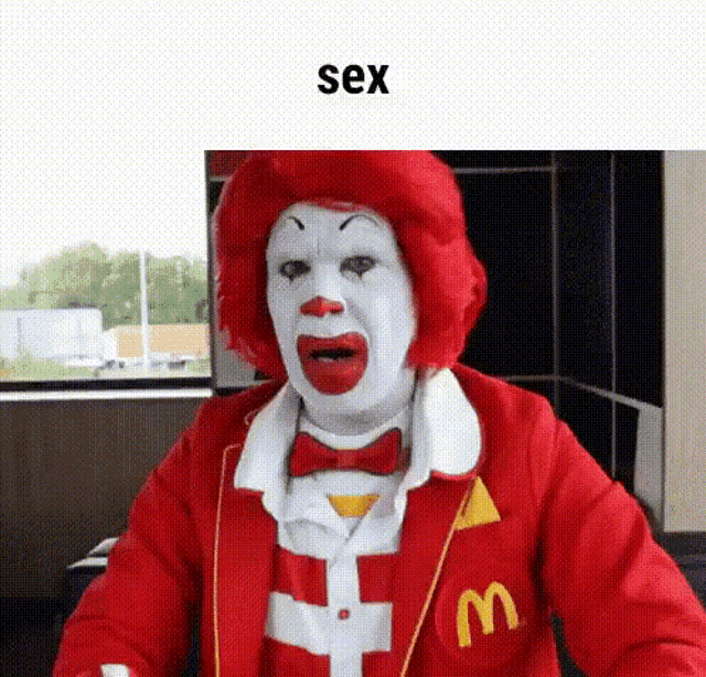 a mcdonald 's clown with a red wig and a white face