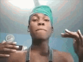 a man with a green bandana on his head is taking a picture of himself