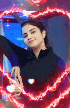 a woman is standing in front of a window with a heart shaped lightning surrounding her .