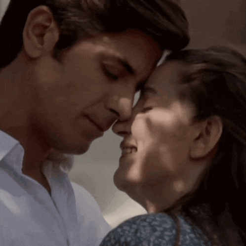 a man and a woman are touching their noses