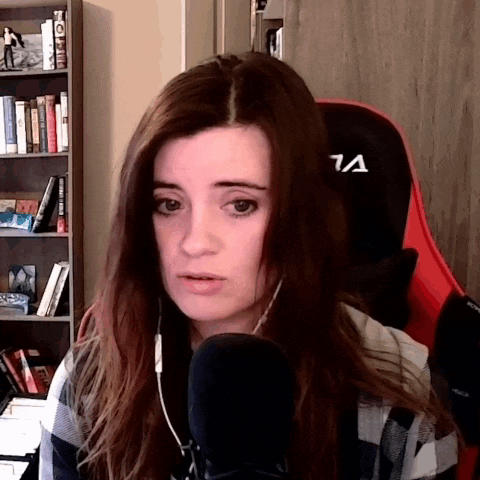 a woman is sitting in front of a microphone with the letter a on her chair