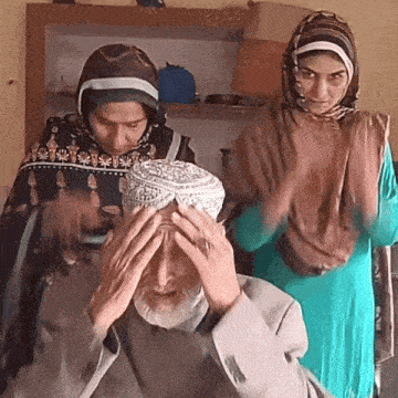 a man with his hands on his head is surrounded by women