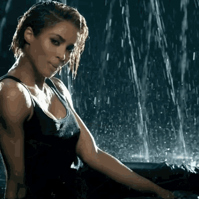 a woman in a tank top is sitting in the rain