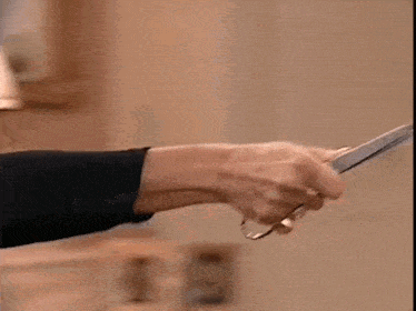 a close up of a person 's hand holding a glass in a room .