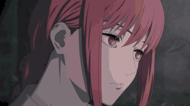 a close up of a girl 's face with red hair and orange eyes
