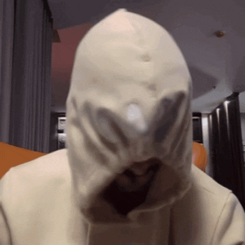 a person wearing a white hoodie with a hole in the front