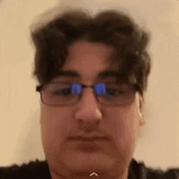 a close up of a man wearing glasses making a face .