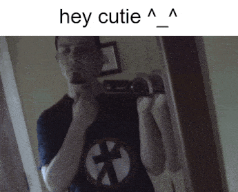 a man is taking a picture of himself in a mirror with the words hey cutie above him