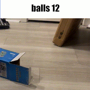 a cardboard box is sitting on a wooden floor next to a box that says balls 12