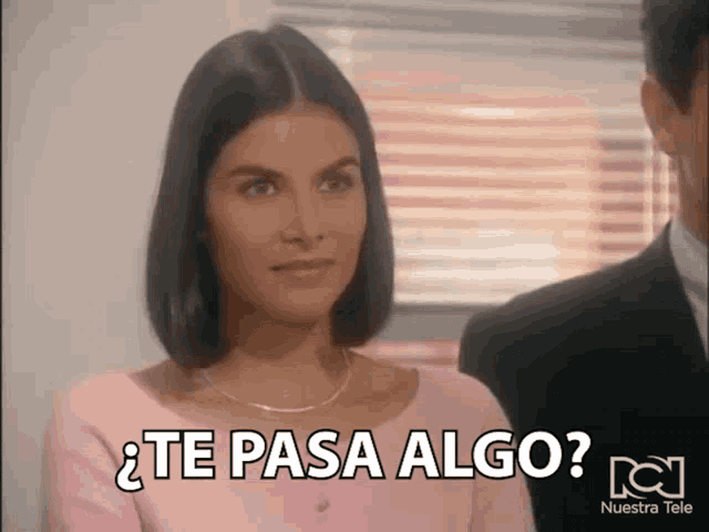 a woman in a pink shirt says " te pasa algo " next to a man in a suit