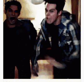 two men are standing next to each other and one is making a funny face .