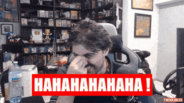 a man is laughing in front of a sign that says ' hahahahaha ! '