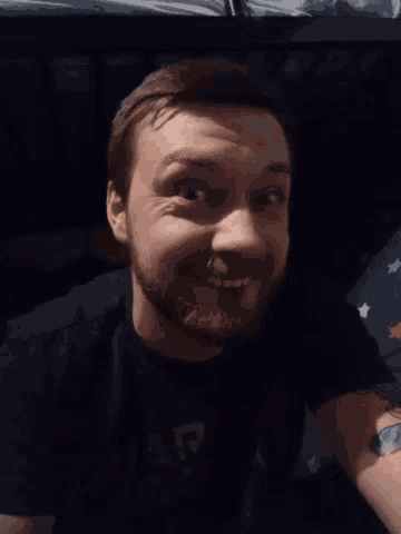 a man with a beard is wearing a black shirt that says army