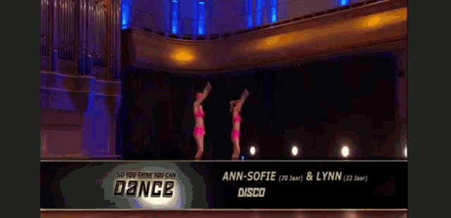 two dancers are performing on a stage with lights on