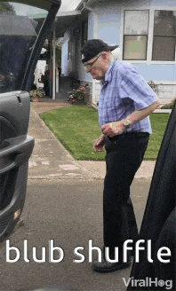 a man in a plaid shirt is standing in front of a house with the words blub shuffle written below him