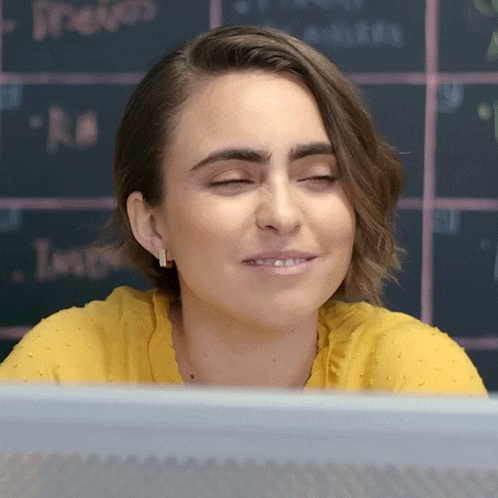 a woman sitting in front of a computer screen with her eyes closed