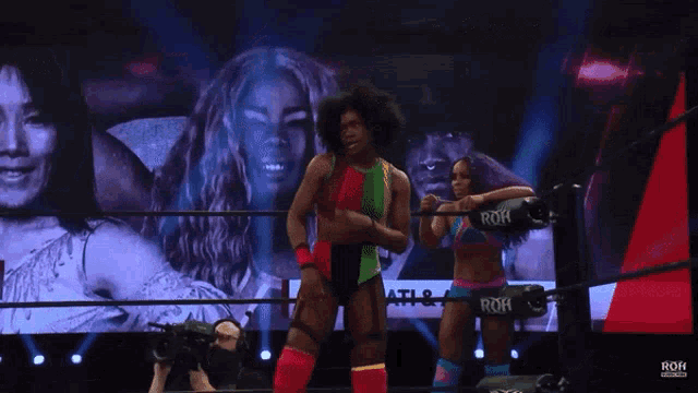 two women in a wrestling ring with a sign that says roh
