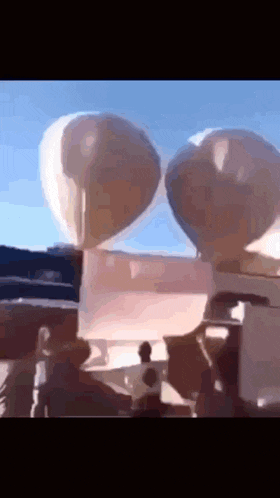 a couple of balloons are floating in the air
