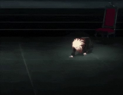 a person is kneeling down on the floor in a dark room .