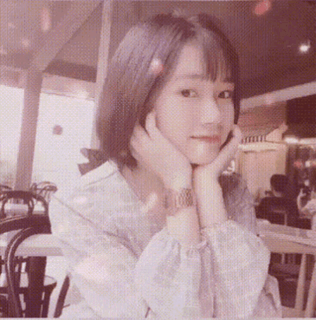 a girl with her hand on her face looks at the camera