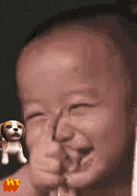 a close up of a baby 's face with a stuffed animal in the foreground that says hi
