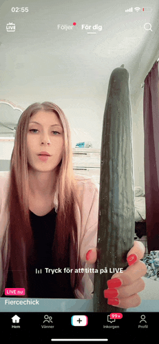 a woman is holding a large cucumber in front of a phone screen that says fiercechick