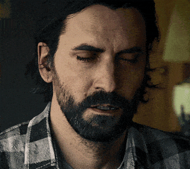 a man with a beard is wearing a plaid shirt and his eyes are closed
