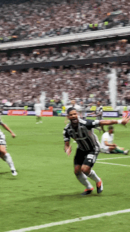 a soccer player wearing a jersey that says ' adidas ' on it is running on the field